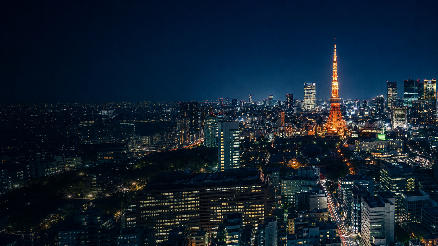 Tokyo Tower and the Tokyo skyline illuminated beneath an indigo night sky
